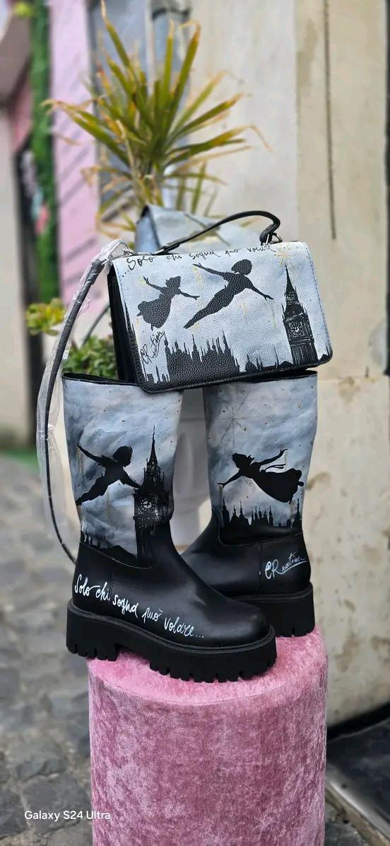 Stivale Dipinto a Mano con Personaggi di Peter Pan - Solo chi sogna può volare + Promo Stivale + Borsa Coordinata Aggiungi un tocco di magia al tuo look con questi stivali dipinti a mano, ispirati al mondo incantato di Peter Pan! Ogni paio è realizzato con cura e dettagli, con due personaggi di Peter Pan che volano nel cielo, accompagnati da uno sfondo mozzafiato. La frase "Solo chi sogna può volare" rende questo prodotto ancora più speciale, perfetto per chi ama sognare e vivere ogni giorno come una nuova 