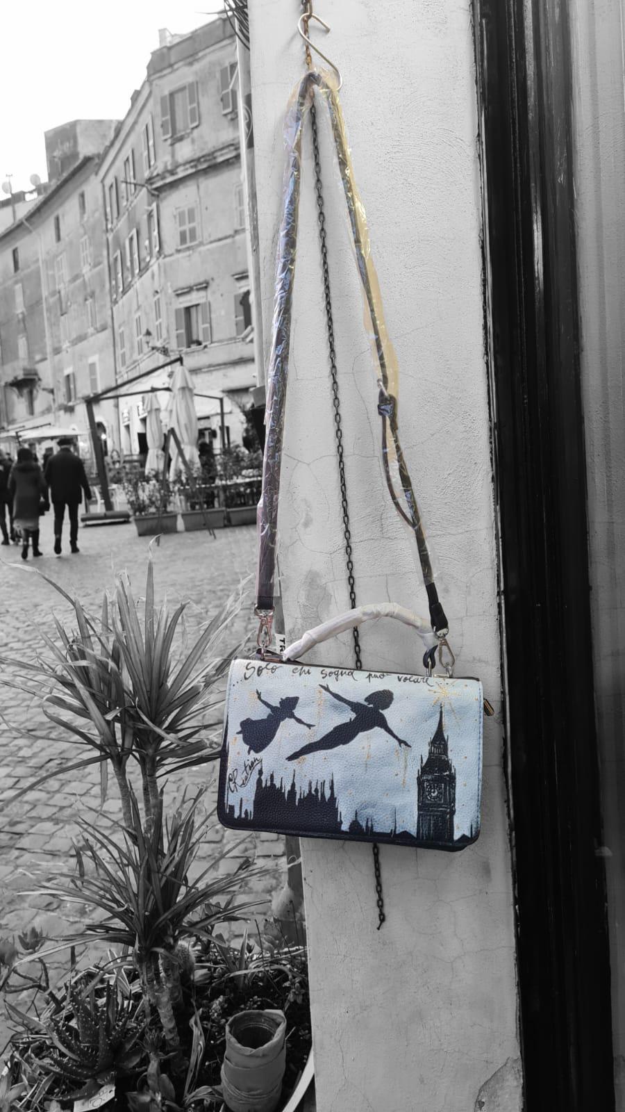 Lasciati trasportare nel mondo magico di Neverland con questa borsa dipinta a mano, raffigurante Peter Pan che vola! Con la frase ispiratrice "Solo chi sogna può volare", questa borsa è un invito a credere nei propri sogni e ad affrontare ogni giorno con un pizzico di magia. Un accessorio unico, perfetto per chi cerca un mix di arte, fantasia e funzionalità. 🧩 *Coordinabile su richiesta:* È possibile ordinare *un portafoglio o un giacchetto perfettamente abbinato* con lo stesso stile e soggetto ! Caratteri