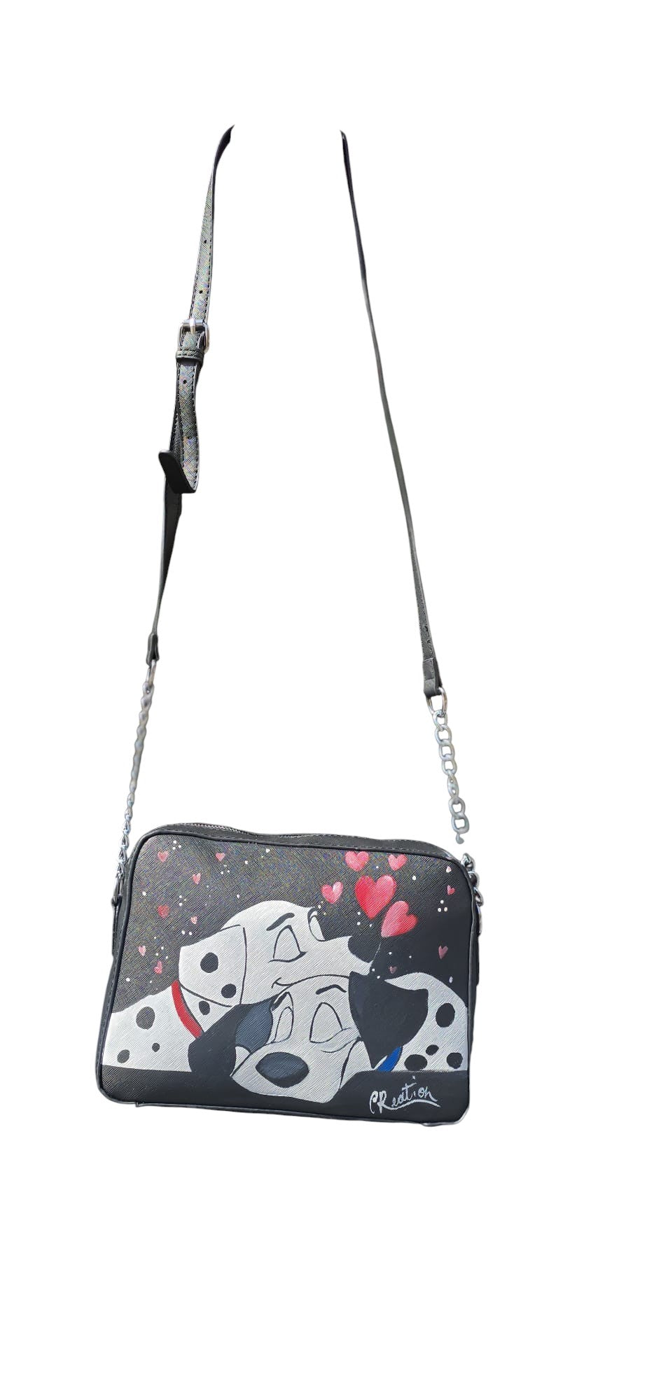 Porta con te la tenerezza e l'allegria dei dalmata più famosi del cinema con questa borsa in ecopelle, dipinta interamente a mano. I protagonisti sono i dolci cuccioli a macchie, riprodotti con cura nei dettagli per chi ama il mondo dei classici e gli accessori che raccontano una storia di amicizia e coraggio.