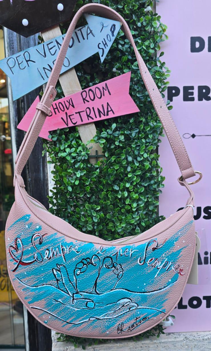 Borsa dipinta a mano – “Sempre e per sempre” 🎨 Borsa artigianale realizzata interamente a mano, con un toccante soggetto: due mani che reggono due piccoli piedini di un bambino, simbolo d’amore eterno e protezione. 👜 Il messaggio "Sempre e per sempre" rende questo accessorio un regalo speciale per mamme, neo-genitori o per celebrare un legame profondo. 📐 Misura: borsa capiente 🧵 Materiale: ecopelle/pelle 💡 Possibilità di richiedere la personalizzazione del soggetto o una frase diversa. 👟 Coordinabile 
