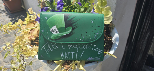 *Borsa Dipinta a Mano – Cappellaio Matto 🎩✨* Un pezzo unico e originale per chi ama il mondo incantato di Alice nel Paese delle Meraviglie! Questa borsa in ecopelle è interamente *dipinta a mano* con colori acrilici professionali e sigillata per durare nel tempo. Il *soggetto principale* è l’iconico *cappello del Cappellaio Matto*, accompagnato dalla celebre frase: *“Tutti i migliori sono matti”*