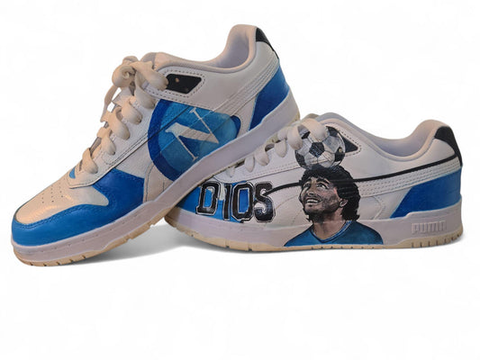 Scarpe Puma dipinte a mano – Maradona &amp; Scudetto Napoli • Arte da indossare • Custom sneakers --- *Descrizione prodotto:* ⚽ *Scarpe Puma dipinte a mano – Diego Armando Maradona &amp; Scudetto Napoli* Un omaggio unico e potente al Pibe de Oro e alla grandezza del Napoli. Un'opera d’arte da indossare, creata interamente a mano con *colori acrilici professionali*, resistenti a usura e intemperie. 👟 Ogni dettaglio è curato con passione: il ritratto di *Maradona*, i colori del *Napoli* e il simbolico *scude