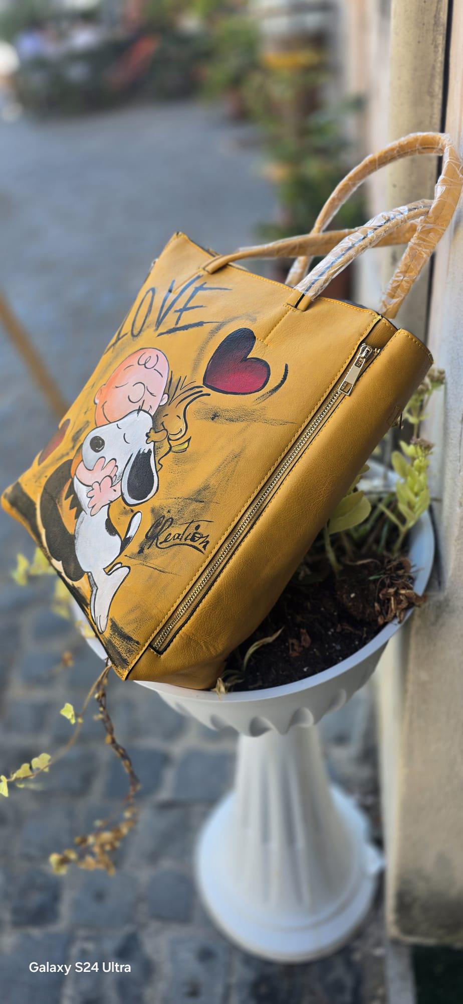 *Titolo:* Borsa grande dipinta a mano – Snoopy *Descrizione:* 🎨 Borsa capiente dipinta a mano, pezzo unico d'artigianato, con protagonista il dolcissimo *Snoopy*, perfetta per gli amanti dello stile creativo e originale. 👜 Realizzata su materiale ecopelle/pelle, resistente e spaziosa, ideale per l’uso quotidiano