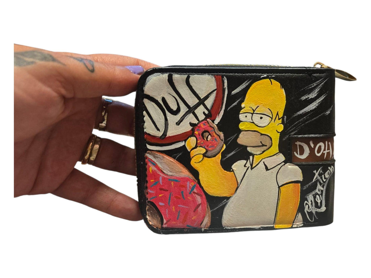 *Titolo:* Portafoglio dipinto a mano – Homer Simpson *Descrizione:* 🎨 Portafoglio artigianale dipinto interamente a mano con protagonista *Homer Simpson*, per chi ama i personaggi iconici e desidera un accessorio unico e originale. 🟡 Realizzato su base in ecopelle/pelle, pratico e resistente, perfetto per un regalo creativo o per chi ama distinguersi. ✨ Personalizzabile su richiesta con nome, frasi o personaggi aggiuntivi. 📦 Disponibilità: - Pronta consegna se disponibili in negozio - In caso di vendita 