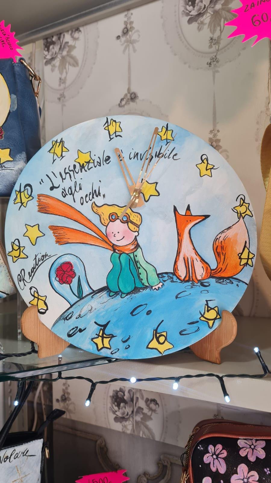 Orologio da Parete Dipinto a Mano - Il Piccolo Principe - Accessorio Unico e Magico per la Tua Casa Descrizione: Aggiungi un tocco di poesia e magia alla tua casa con questo orologio da parete dipinto a mano, ispirato al celebre Piccolo Principe. Ogni dettaglio di questo orologio è realizzato con cura per catturare l’essenza senza tempo di questa storia, trasformando un semplice oggetto quotidiano in una vera e propria opera d’arte.
