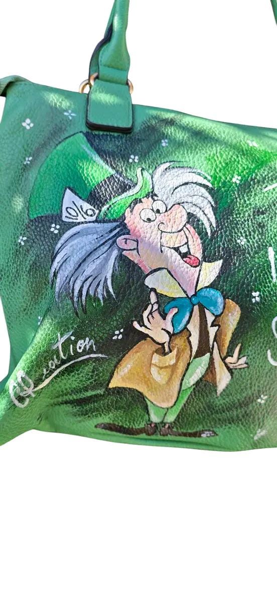 Borsa Dipinta a Mano con Cappellaio Matto - “Tutti i migliori sono matti” - Ecopelle - Personalizzabile 🧩 *Coordinabile su richiesta:* È possibile ordinare *un portafoglio o un giacchetto perfettamente abbinato* con lo stesso stile e soggetto ! Descrizione: Questa borsa dipinta a mano è un omaggio al famoso Cappellaio Matto, personaggio iconico del celebre cartone animato.