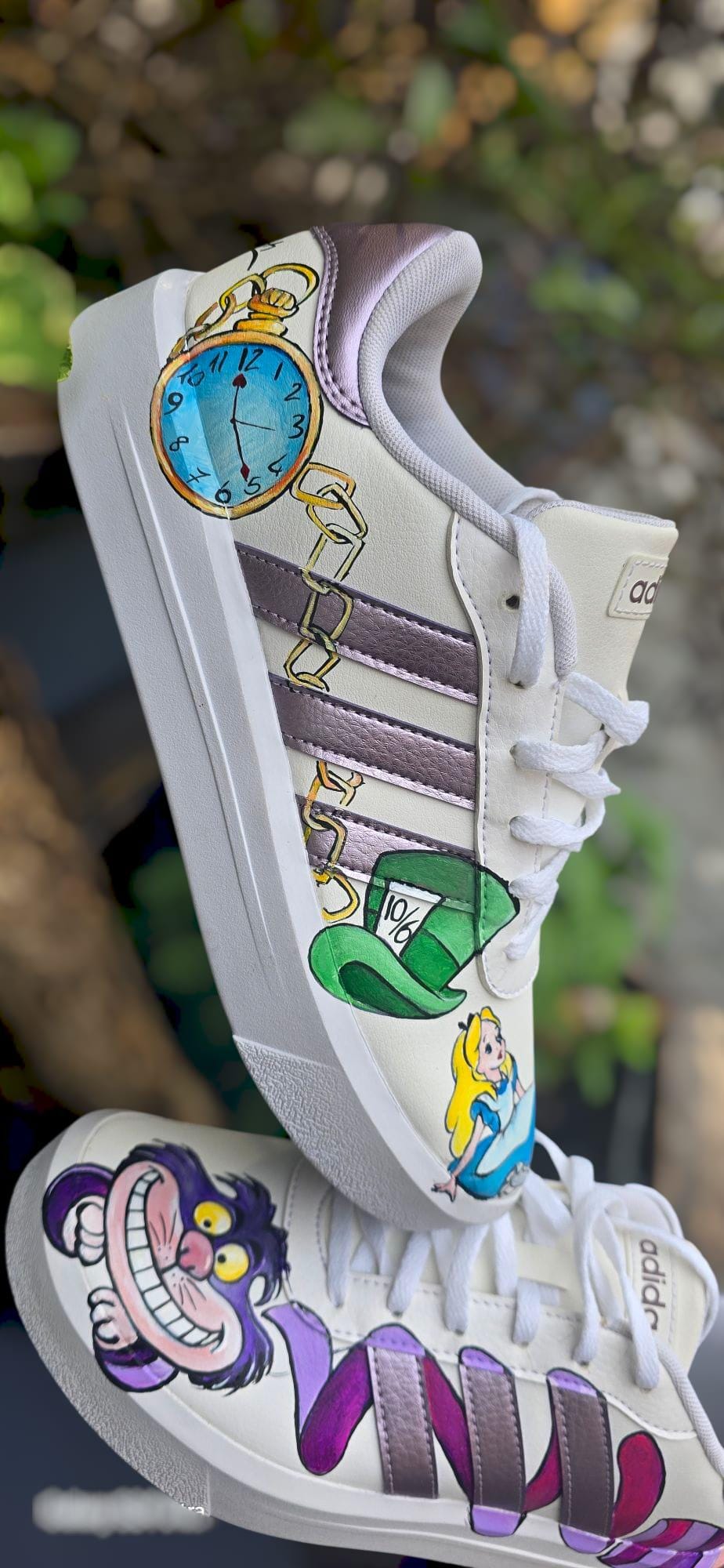 Adidas Personalizzate – Tema Alice &amp; Stregatto 🎨🐱👓 Un tuffo nel Paese delle Meraviglie ai tuoi piedi! Queste Adidas dipinte a mano sono decorate con un’esclusiva personalizzazione ispirata a Alice nel Paese delle Meraviglie e al mitico Stregatto, perfette per chi ama la fantasia, l’arte e lo stile unico. Ogni dettaglio è curato a mano con colori acrilici professionali e protetto da una finitura resistente per garantire durata e originalità. 🐇🌈 🧩 *Coordinabile su richiesta:* È possibile ordinare *u