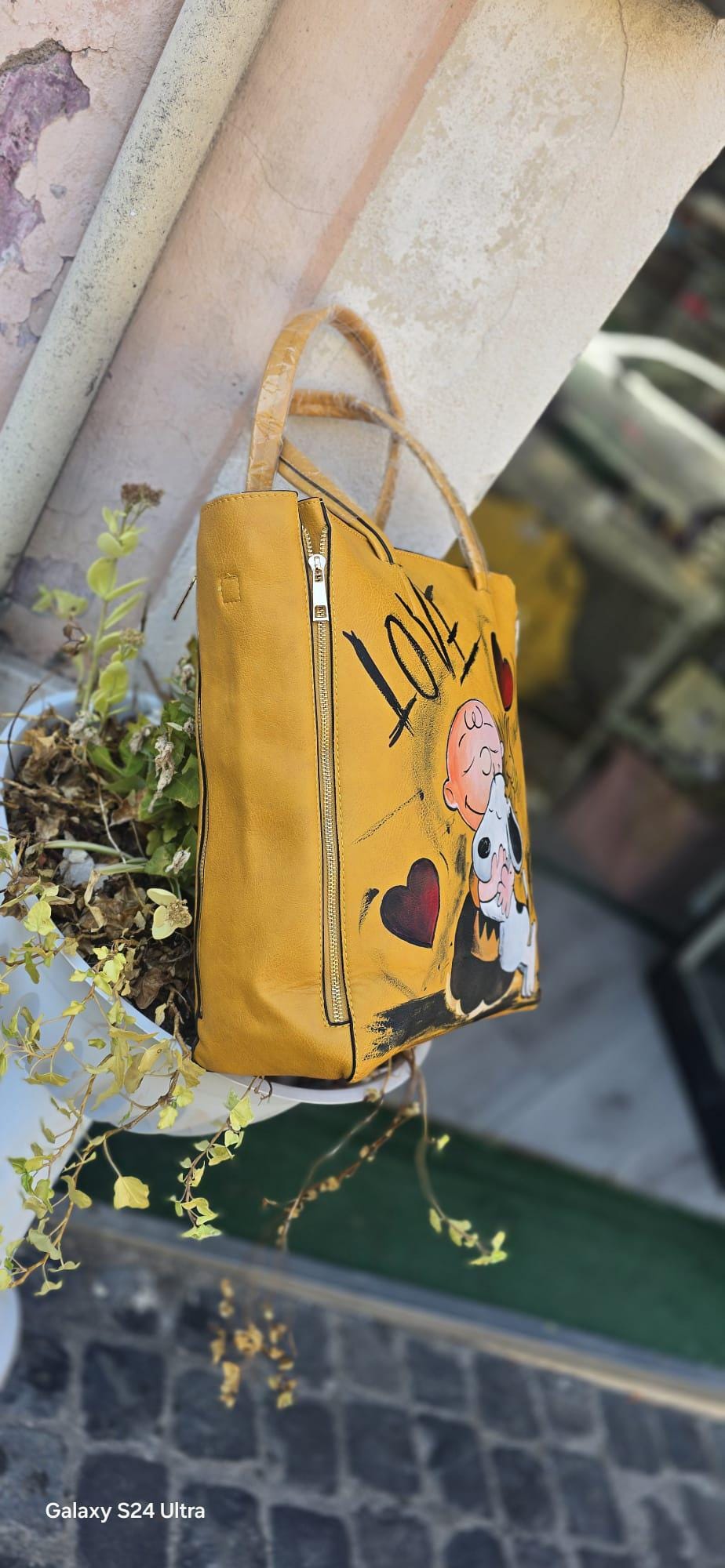 *Titolo:* Borsa grande dipinta a mano – Snoopy *Descrizione:* 🎨 Borsa capiente dipinta a mano, pezzo unico d'artigianato, con protagonista il dolcissimo *Snoopy*, perfetta per gli amanti dello stile creativo e originale. 👜 Realizzata su materiale ecopelle/pelle, resistente e spaziosa, ideale per l’uso quotidiano