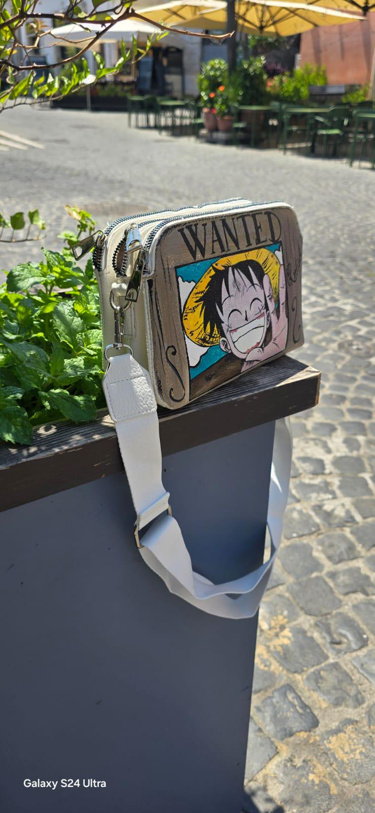 *Borsa Dipinta a Mano – Rubber Cappello di Paglia (One Piece) 🏴☠️🎨* Un accessorio unico per veri fan di One Piece! Questa *borsa in ecopelle dipinta a mano* ha come soggetto principale *Rubber (Luffy)* con il suo iconico *cappello di paglia*, simbolo di libertà e avventura. Realizzata con *colori acrilici professionali*, ogni borsa è un pezzo artigianale unico, perfett