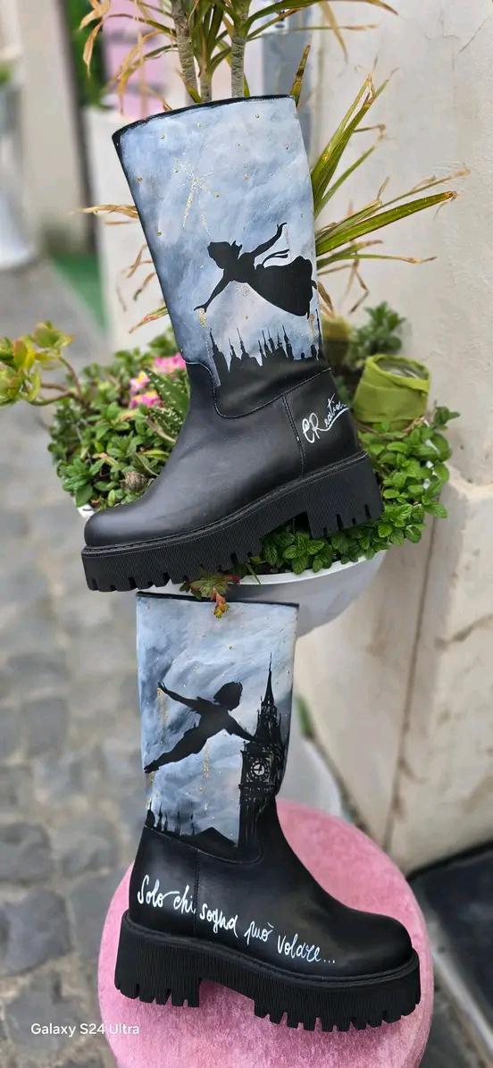 Stivale Dipinto a Mano con Personaggi di Peter Pan - Solo chi sogna può volare 🧩 *Coordinabile su richiesta:* È possibile ordinare *un portafoglio , una borsa o un giacchetto perfettamente abbinato* con lo stesso stile e soggetto ! Aggiungi un tocco di magia al tuo look con questi stivali dipinti a mano, ispirati al mondo incantato di Peter Pan! Ogni paio è realizzato con cura e dettagli, con due personaggi di Peter Pan che volano nel cielo, accompagnati da uno sfondo mozzafiato. La frase "Solo chi sogna p