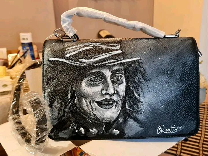 Borsa Dipinta a Mano - Il Cappellaio Matto | Alice nel Paese delle Meraviglie | Accessorio Unico ✨ Un tocco di follia e magia per il tuo stile! ✨ Questa borsa unica è dipinta a mano con colori acrilici resistenti e raffigura il Cappellaio Matto, uno dei personaggi più iconici e stravaganti di Alice nel Paese delle Meraviglie! Un accessorio perfetto per gli amanti del mondo Disney e per chi vuole aggiungere un tocco di originalità e fantasia ai propri outfit