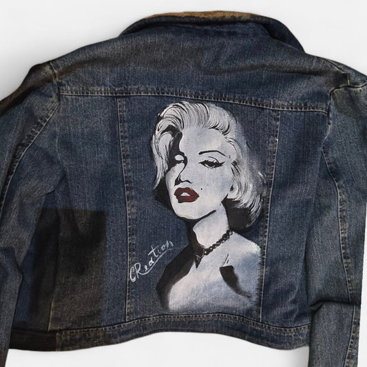 ✨ Il Soggetto: Marilyn Monroe
Porta con te il mito del cinema con questa giacca dipinta interamente a mano. La protagonista è Marilyn Monroe, l'icona della bellezza e della femminilità, riprodotta con cura artigianale nei minimi dettagli. Un capo pensato per chi non vuole passare inosservato e ama gli accessori che fondono moda e arte.