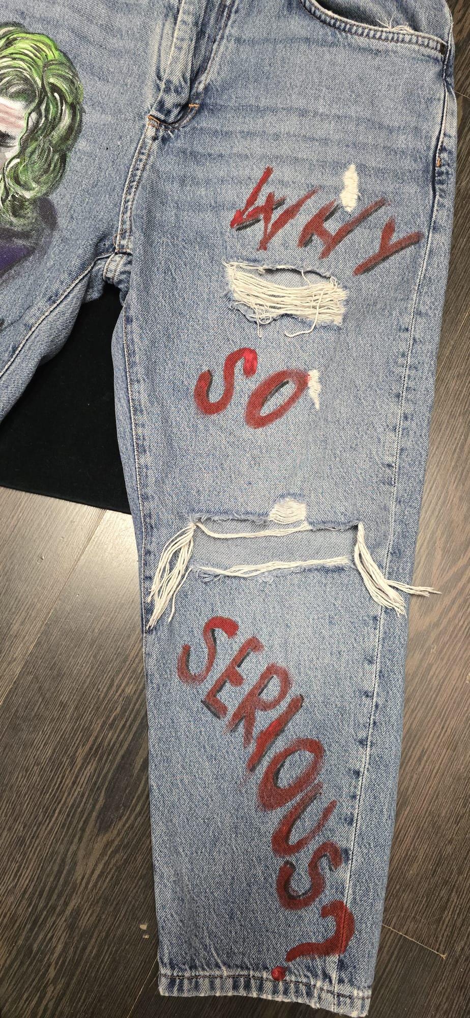 🎨 Descrizione prodotto:  
Pezzo audace e d’impatto per chi ama distinguersi: pantaloni in jeans dipinti a mano con il volto iconico del Joker accompagnato dalla celebre frase "Why so serious?". Ogni dettaglio è realizzato a mano con passione, rendendo questo capo una vera opera d’arte da indossare.