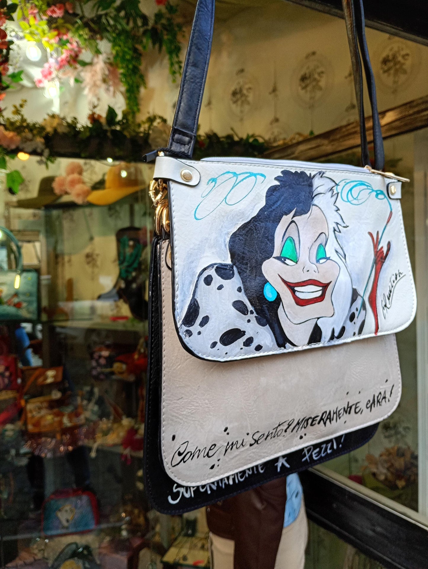 Lasciati conquistare dal fascino ribelle e dallo stile inconfondibile di *Crudelia De Mon*, protagonista di questa *borsa dipinta a mano*. Un accessorio iconico, perfetto per chi ama distinguersi con carattere e un tocco di ironia dark