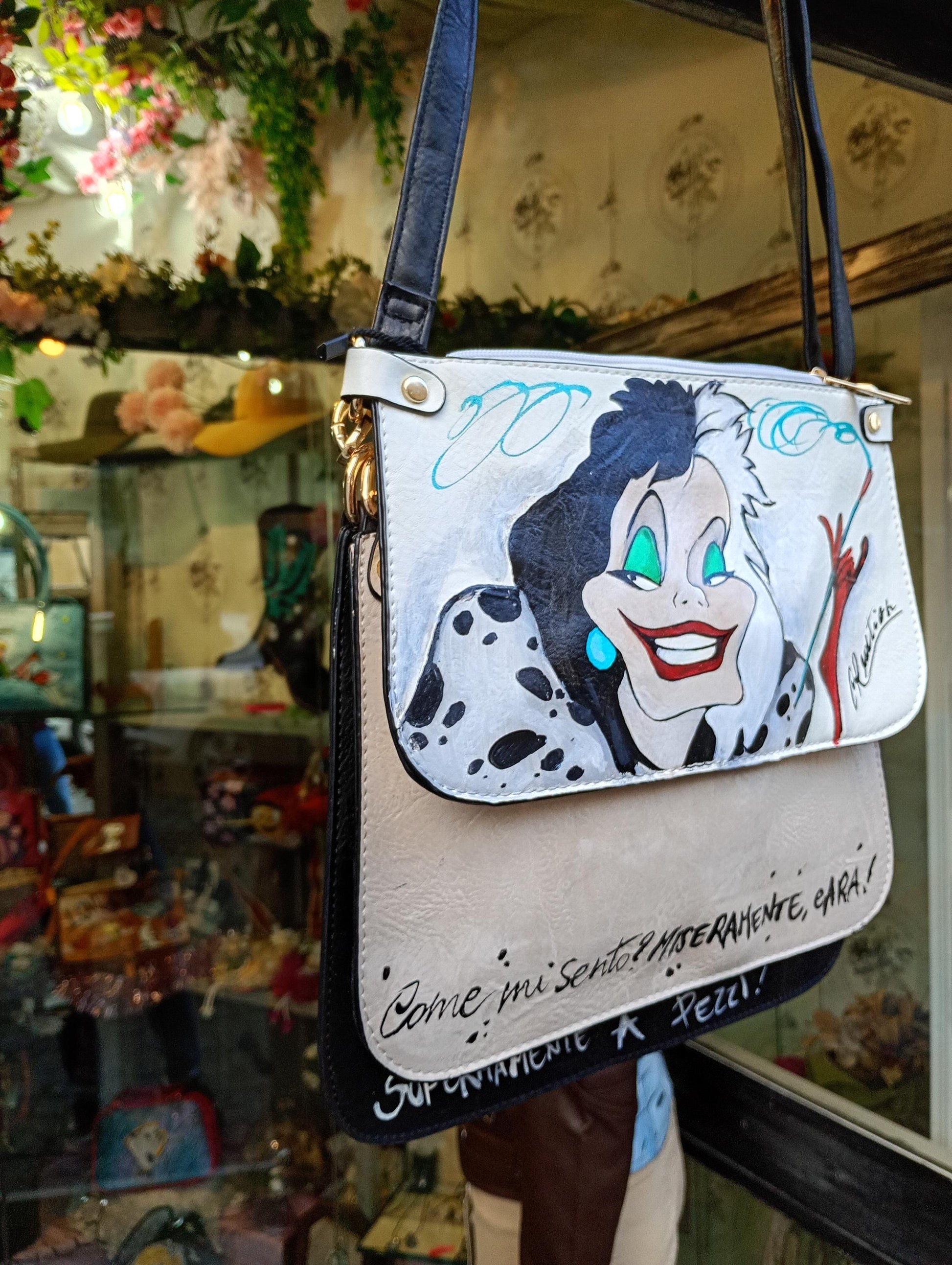 Lasciati conquistare dal fascino ribelle e dallo stile inconfondibile di *Crudelia De Mon*, protagonista di questa *borsa dipinta a mano*. Un accessorio iconico, perfetto per chi ama distinguersi con carattere e un tocco di ironia dark