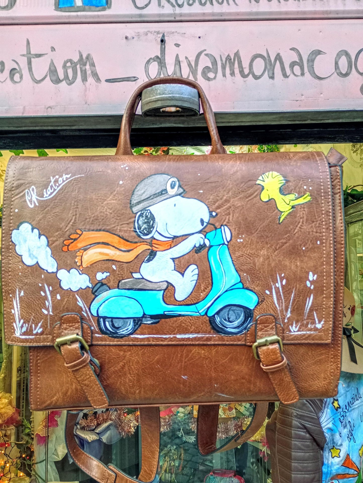 Descrizione prodotto:  
Borsa zaino dipinta a mano Snoopy su moto Peanuts, ecopelle artigianale personalizzabile
