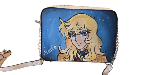 Rendi omaggio alla leggendaria comandante delle Guardie Reali con questa borsa in ecopelle, dipinta interamente a mano. Il volto di Oscar, con la sua forza e la sua eleganza, è riprodotto con estrema cura nei dettagli per chi ama la storia, il classicismo degli anime e gli accessori che raccontano una storia di libertà e valore.
*🧩 Coordinabile su richiesta:* È possibile ordinare un portafo