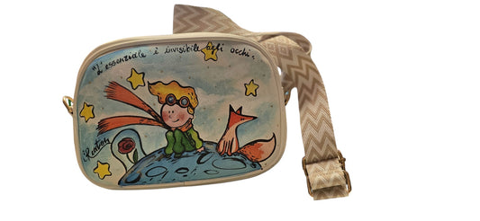 ​*✨ Il Soggetto: Il Piccolo Principe*
Porta con te la poesia del capolavoro di Saint-Exupéry con questa borsa in ecopelle, dipinta interamente a mano. Il protagonista, con i suoi capelli d'oro e il suo scialle al vento, è riprodotto con cura nei dettagli per chi ama sognare e desidera un accessorio che racconti una storia di amicizia e scoperta.